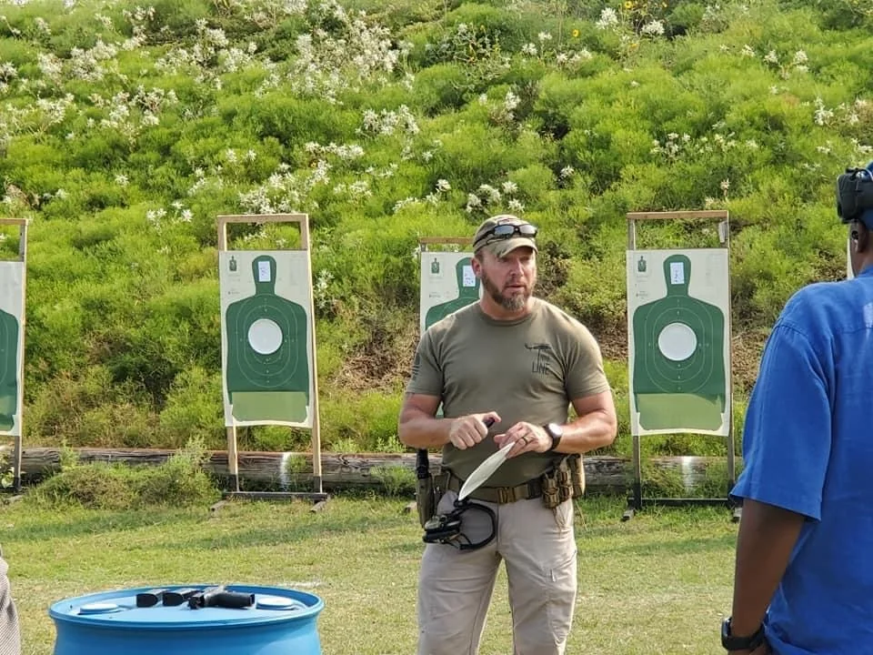 J. Todd Nunley speaking with a trainee at an outdoor training range